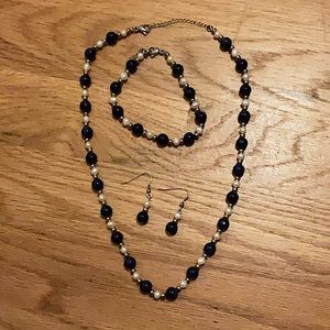 A three piece necklace, earrings, and bracelet blue and white pearl set